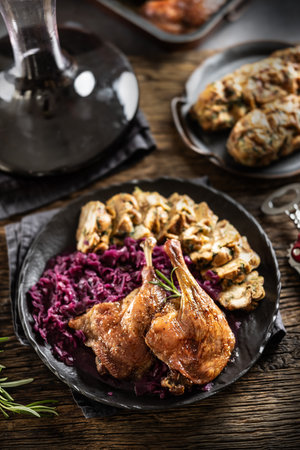 Portion of roast duck leg red cabbage homemade dumplings on plate and red wine on the background.の写真素材