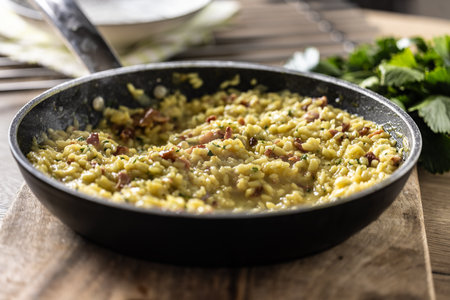 Italian risotto with pancetta, parmesan and parsley in a pan.の写真素材