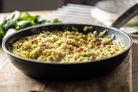 Italian risotto with pancetta, parmesan and parsley in a pan.の写真素材