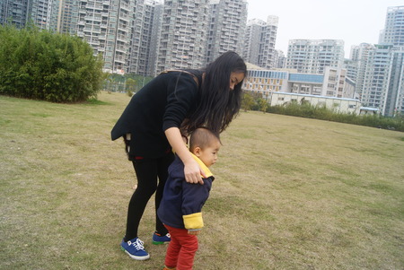 The young mother and her children playing in the park, in Shenzhenのeditorial素材