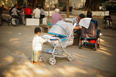 The baby carriage is pushed to rotate a child, a park in Shenzhen, Chinaのeditorial素材