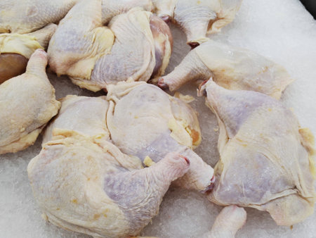 Raw chicken legs on ice in the market, closeup of photoの写真素材