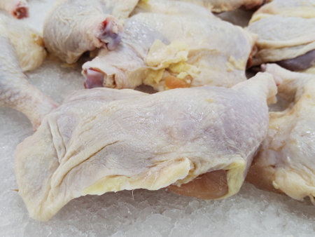 Raw chicken legs on ice in the market, closeup of photoの写真素材