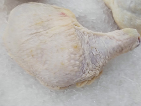 Raw chicken leg on ice in the market. Close up view.の写真素材