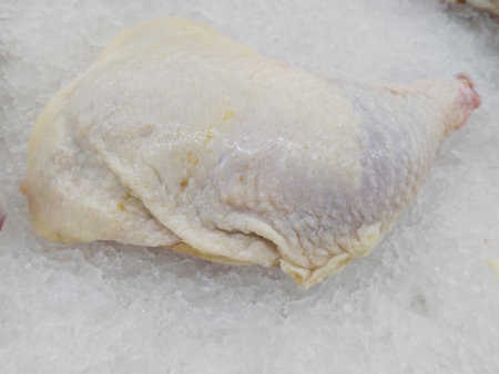 Raw chicken leg on ice in the market, closeup of photoの写真素材
