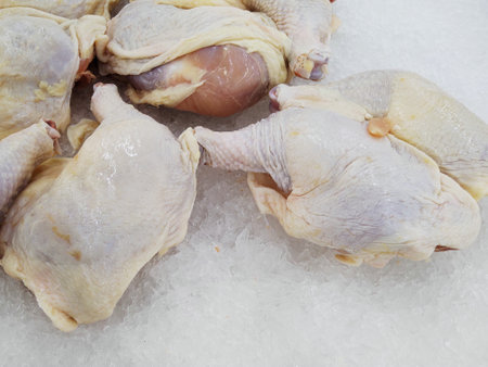 Raw chicken legs on ice in the market, closeup of photoの写真素材