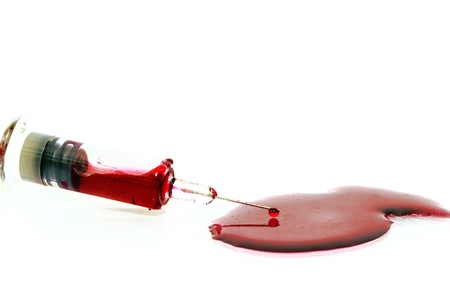 isolated red blood in injection syringe have blood droplet drop at end of needle and have blood on floor on white backgroundの写真素材
