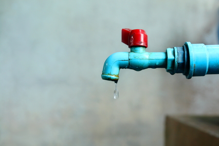 Old blue water tab have water drip out, concept shortage water in World for Water Day, have copyspace for put textの写真素材