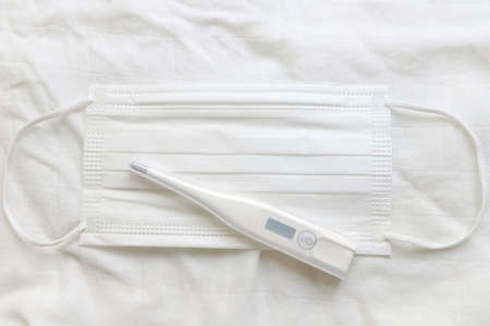 Closeup mercury and white mask on white background, top view, concept supplies for protection outbreak corona virus (covid19)の写真素材