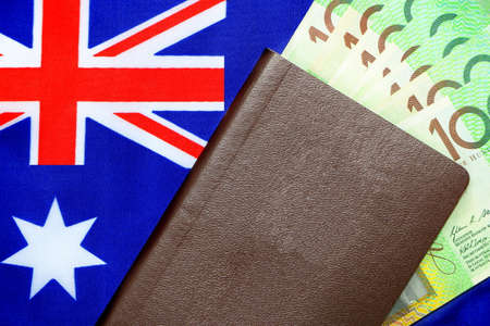 100 Australian green cash money with passport on Australia flag background. Concept travel by yourself ,tour or go to learn at Australiaの写真素材