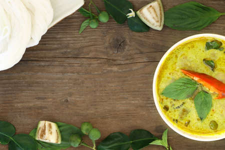 Top view of green curry fish ball served with Thai rice vermicelli in white bowl on wood table, look delicious. Have copy space for put text.の写真素材