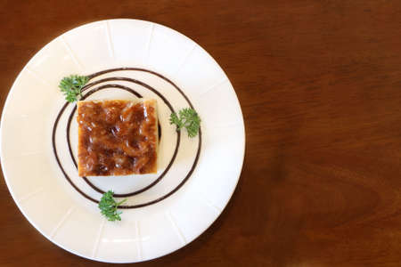 Top view of toffee cake in white plate on wooden table look delicious, have copy spaceの写真素材