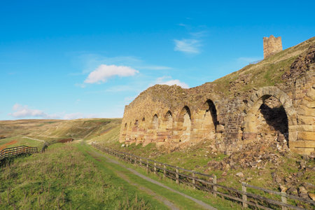 The ruins of the ironstone kilns used for roasting the ore mined from the hillside, East Rosedale Mines on the Rosedale Ironstone Railway, North York Moors National Park, UKの写真素材