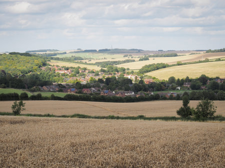 Looking back over a wheat field and down to the village of Lambourn from Coppington Hill, Berkshire, UKの写真素材