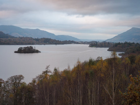 Dusk over Derwent Water with orange and gold Autumn colours in the trees, Lake District, UKの写真素材
