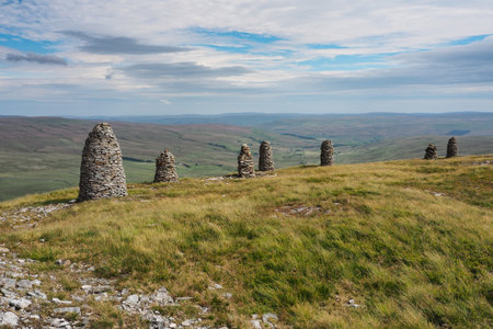 Multiple cairns standing tall at the summit of High White Scar, next to Wild Boar Fell, overlooking the Eden Valley, Cumbria, UKの写真素材