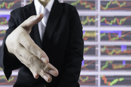 Business women handshake with stock graph blur for background in stock success conceptの写真素材