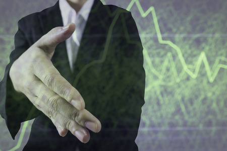 Business women handshake with stock graph blur for background in stock success conceptの写真素材