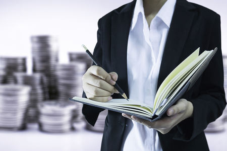 Business women working check list in stack of coin background concept check mind saving moneyの写真素材