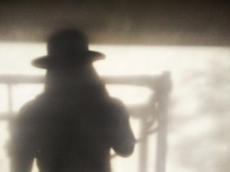 shadow hat man and polish plaster wall background with copy spaceの写真素材