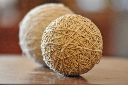 Two twine rolled balls sit on a table.の素材
