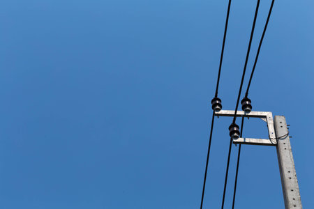 High voltage power, electric pose and electric cords stand alone with sky background in toned colour...