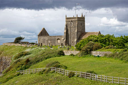 Storm clouds over St Nicholas Old Church, Uphill, Weston Super Mare, Somerset 
11th century Norman church on top of the cliffs with Bristol Chanel & Welsh coast behind. Grade II listedの写真素材