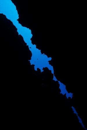 Blue water shows through a narrow crack exit from an underwater cave in the Red Seaの写真素材