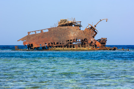 Rusting metal shipwreck on a tropical coral reefの写真素材