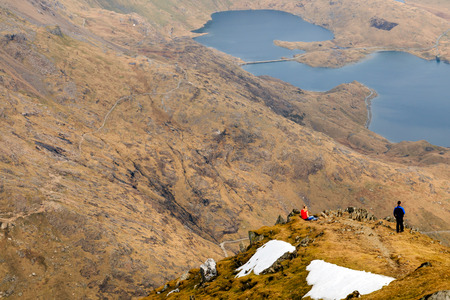 People looking down at the view from a mountaintopの写真素材