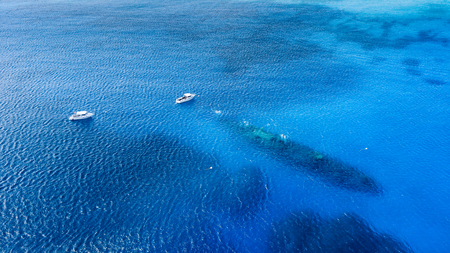 Boat over the shipwreck of the USS Kittiwake in Grand Caymanの写真素材