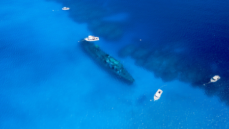 Dive boats over a large shipwreck in clear, blue, tropical watersの写真素材
