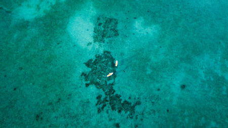 Aerial view of stand up paddleboards over a tropical coral reefの写真素材
