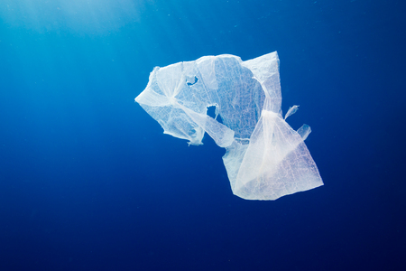 A discarded plastic bag floating in open ocean.  Plastic pollution is a rapidly growing environmental problem.の写真素材