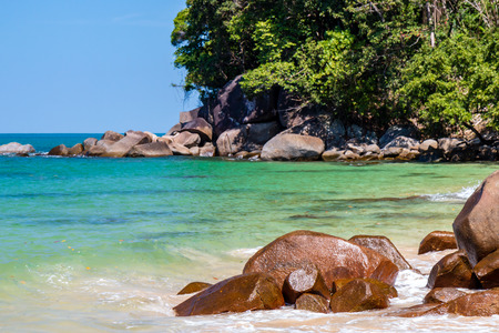 A beautiful, deserted tropical sandy beach surrounded by greeneryの写真素材