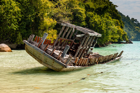 Broken traditional wooden boats in a shallow, tropical lagoon in Thailandの写真素材