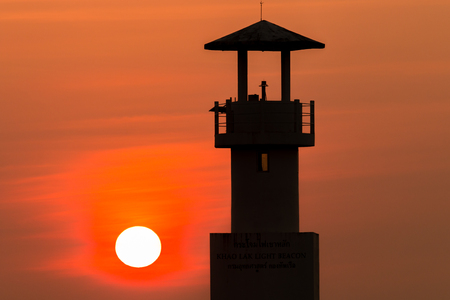 Beautiful tropical sunset behind a silhouette of a lighthouseの写真素材