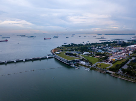 Aerial drone view of Singapore Marina Barrage with ships waiting out to seaのeditorial素材