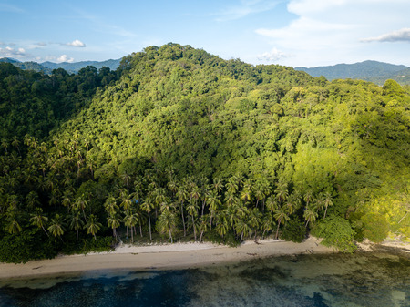 Aerial drone view of a beautiful tropical bay with reef, sandy beach and jungle scenery