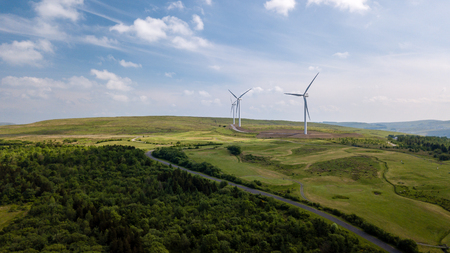 Aerial view of large wind turbines on a rural hillside in Walesの写真素材