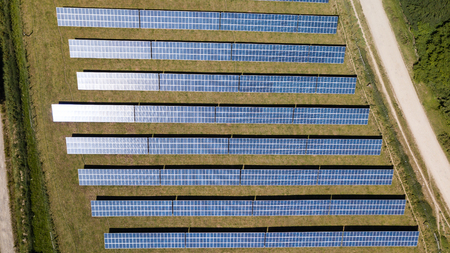 Aerial drone view of lines of solar panels at a generation farm