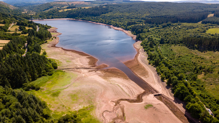 Aerial drone view of a drying reservoir in Wales during a heatwave (Llwyn-On Reservoir)