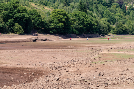 Tourists exploring an empty reservoir in the UK during a summer heatwaveの写真素材