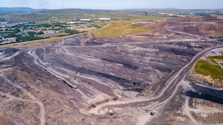 Aerial drone view of a huge opencast coal mine cut into a rural hilly area (Dowlais, Merthyr Tydfil,...