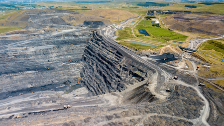 Aerial drone view of a huge opencast coal mine cut into a rural hilly area (Dowlais, Merthyr Tydfil, Wales)の写真素材