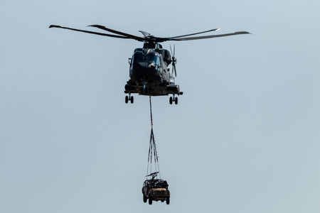 RNAS YEOVILTON, ENGLAND - July 07, 2018: A Royal Navy Merlin HC3 helicopter with an underslung...