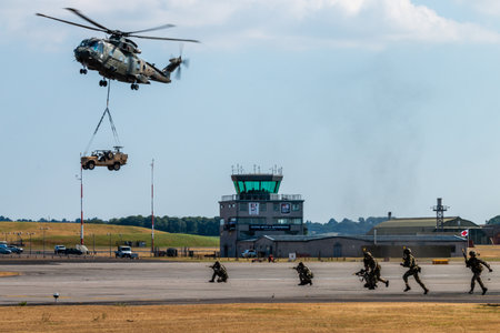 RNAS YEOVILTON, ENGLAND - July 07, 2018: A Royal Navy Merlin HC3 helicopter with an underslung...