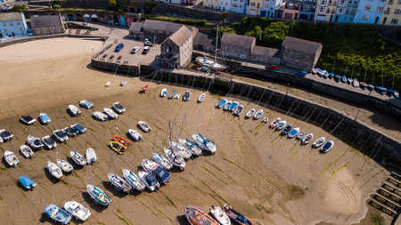 Aerial drone view of fishing boats beached at low tide in a harbour at the beautiful Welsh holiday resort of Tenbyのeditorial素材