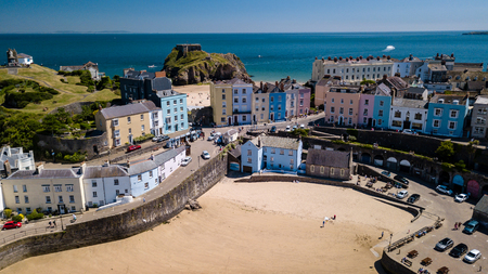 Aerial drone view of colorful buildings next to the ocean in a picturesque seaside town (Tenby, Wales, UK)の写真素材