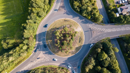 Top down aerial view of a traffic roundabout on a main road in an urban area of the UK